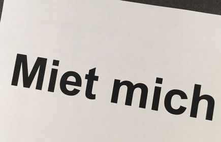 Schwarzer Schriftzug Miet mich auf weißem Papier